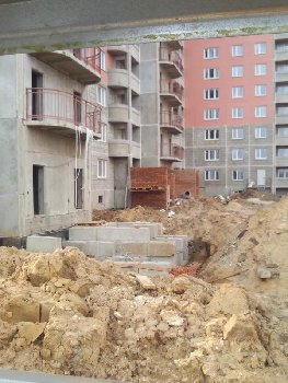 за стеночкой человек не спеша кладет кирпич у 2 секции
